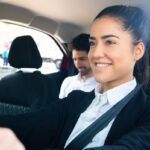 Femme conductrice souriante avec passager masculin dans la voiture