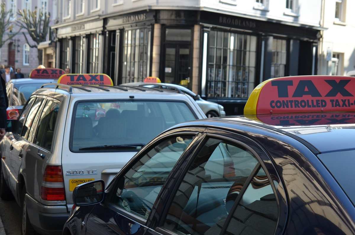 Des taxis attendent en rangée devant un immeuble urbain