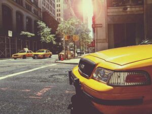 Des taxis jaunes circulent sur une rue de ville ensoleillée