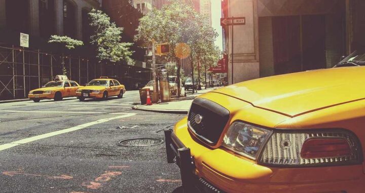 Des taxis jaunes circulent sur une rue de ville ensoleillée