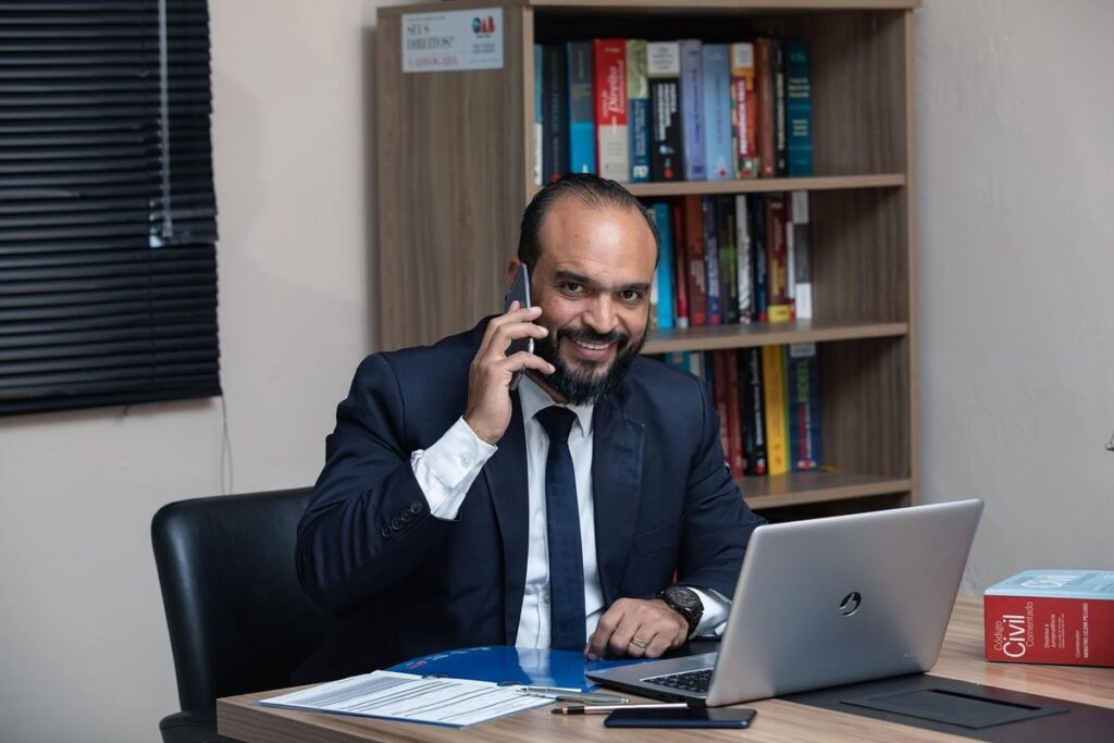 Homme d'affaires en costume téléphonant à son bureau avec ordinateur portable et documents