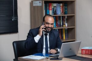 Homme d'affaires en costume téléphonant à son bureau avec ordinateur portable et documents