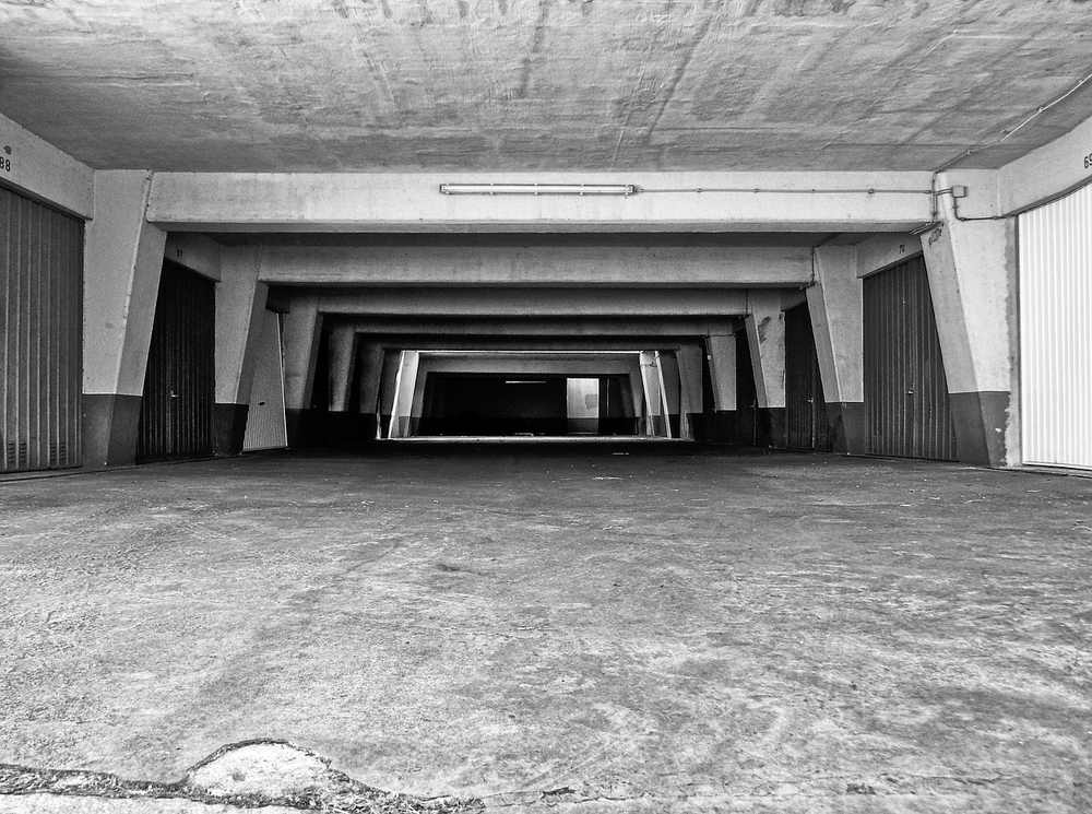Vue d'un parking souterrain vide avec colonnes et sol en béton