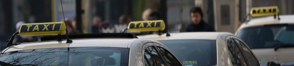 Plusieurs voitures taxis avec panneaux lumineux 'TAXI' sur leurs toits