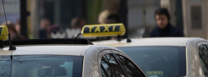 Plusieurs voitures taxis avec panneaux lumineux 'TAXI' sur leurs toits