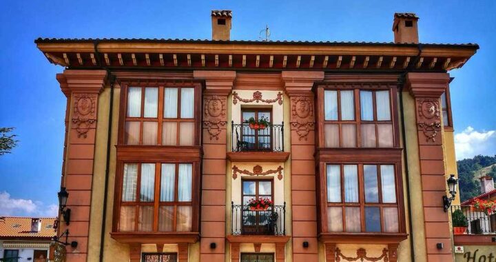 Façade rose d'un hôtel de trois étages sous ciel bleu