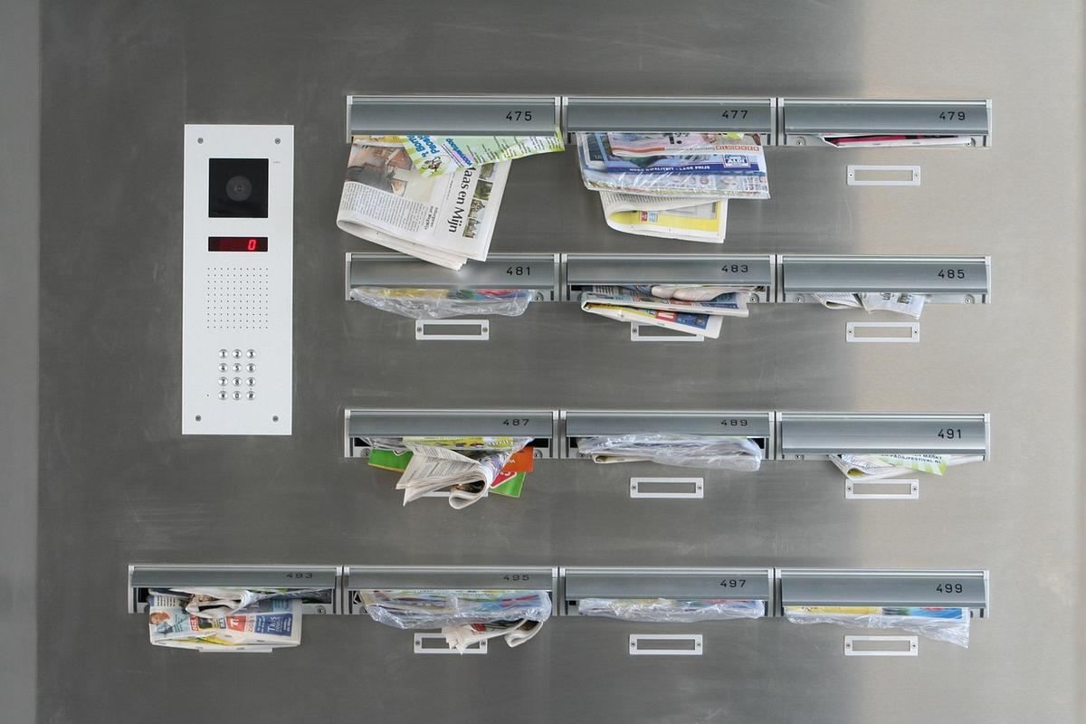 Boîtes aux lettres remplies de courrier sur une porte d'entrée