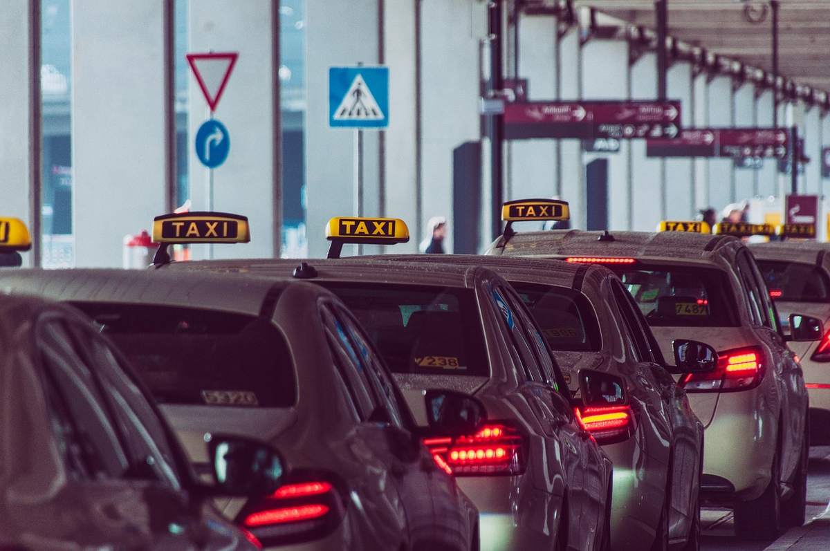 Une rangée de taxis attend au point d'embarquement d'un aéroport Une rangée de taxis attend au point d'embarquement d'un aéroport