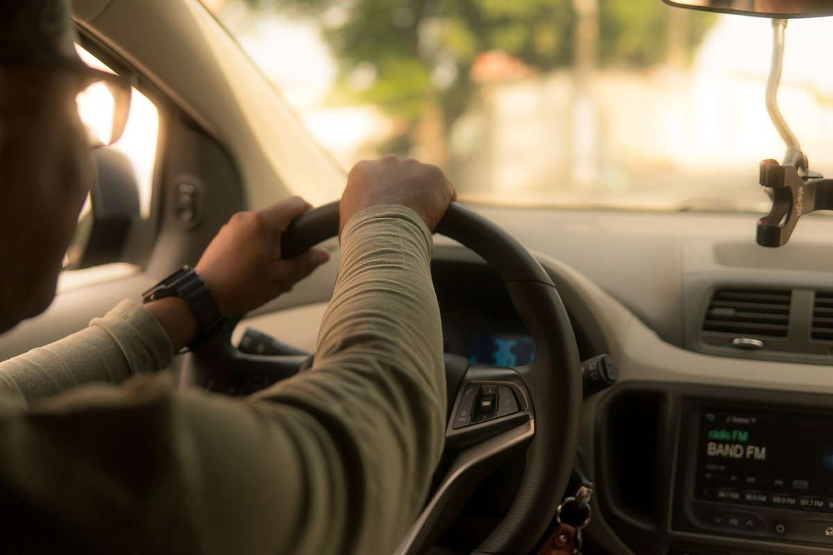 Personne au volant d'une voiture, main sur le volant, radio allumée Personne au volant d'une voiture, main sur le volant, radio allumée